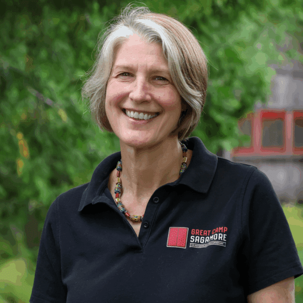 Headshot of woman in black button up shirt with Sagamore logo on it