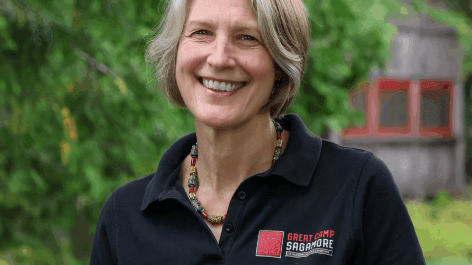 Headshot of woman in black button up shirt with Sagamore logo on it