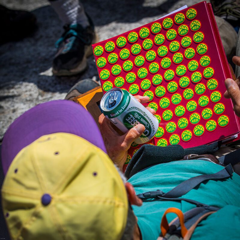 Gary Koch with a sheet of buttons, each on representing a round of hiking all 46 Adirondack High Peaks. He recently completed his 100th round of the hiking challenge. 